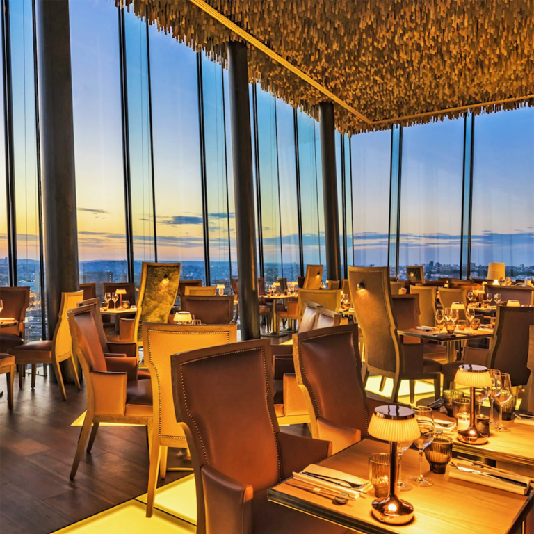 Intérieur d'un restaurant élégant avec vue sur un coucher de soleil.