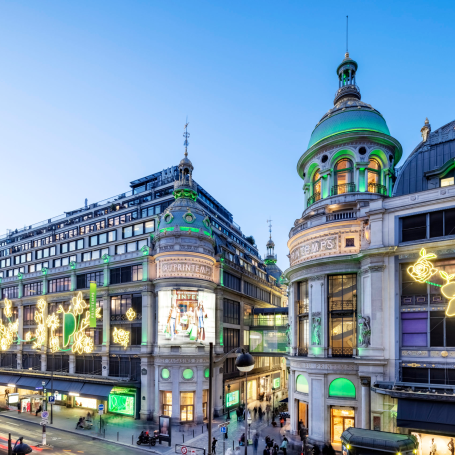 Grand magasin illuminé avec une architecture élégante, ambiance festive en soirée.