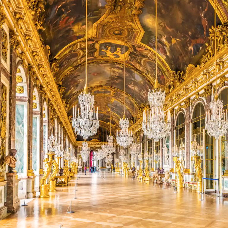 Salon avec un plafond doré, lustres brillants et murs ornés de miroirs.