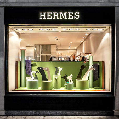 Vitrine de la boutique Hermès avec des sculptures d'animaux et des éléments de design élégant.
