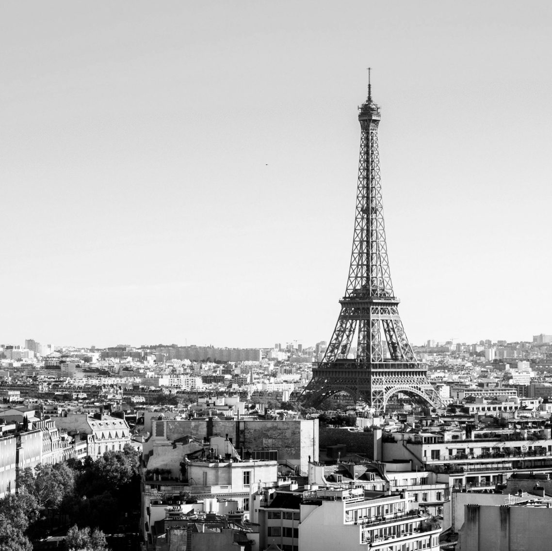 Vue panoramique de Paris avec la tour Eiffel au centre, en noir et blanc.